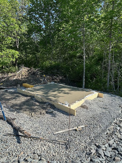 Pouring concrete in the slab forms for both the larger and smaller shed