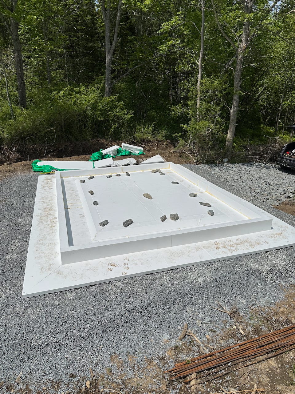 The full FastSlab passive spec forms assembled, and being held down by rocks while the glue sets.