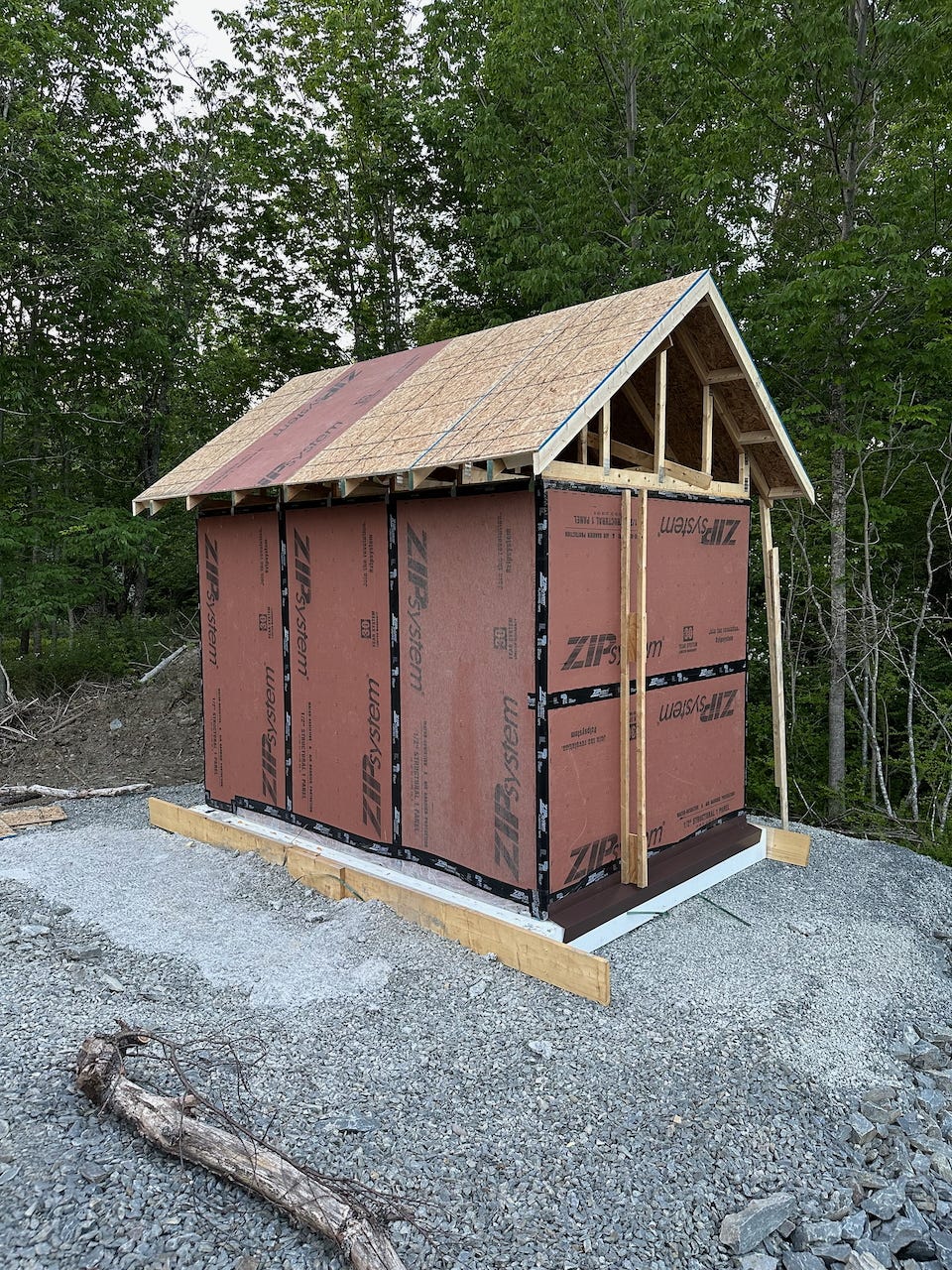 Completed roof sheathing installed over trusses on the shed